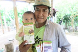 Foto de campesino con su bebé mordiendo chocolate